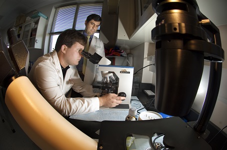 medical student using a microscope in a laboratory